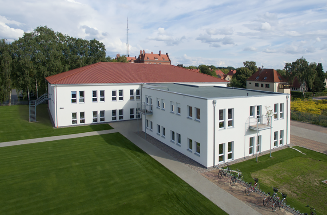 Modernes weißes Ärztehaus mit rotem Flachdach und Rasenfläche in Neuruppin